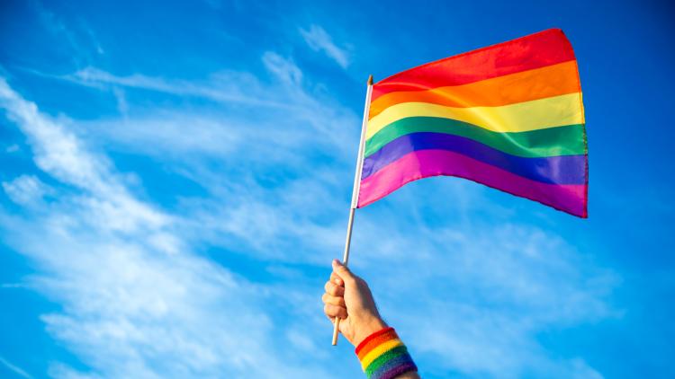 Mann schenkt Regenbogenflagge.